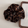 Nahaufnahme eines flauschigen Samt-Haargummis mit Leopardenmuster und weichem Kunstfell - Scrunchie / Samt Dunkles Leopardenmuster - Haargummi