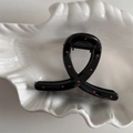 Close-up of black hair claw clip with red polka dots on a white shell-shaped plate - Black Red Polka Dot Twisted Cross Style