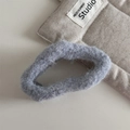 Dettaglio dell'elastico per capelli in peluche grigio con riflessi argentati e texture morbida - Nuvola