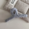 Vue détaillée de la pince à cheveux en peluche bleu clair avec texture douce et pailletée - Style Grand Cintre