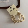 Detailed macro view of yellow braided elastic hair band with a brand display card - Yellow