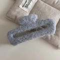 Dettaglio della pinza per capelli in feltro grigio con morbida texture pelosa - Rettangolo