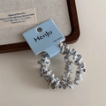 Detail of light blue spiral braided elastic hair ties set on a white minimalist background - Blue