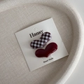 Details von roten Haarklammern mit Karomuster und Herzform auf Displaykarte - Braunrot Gingham Herz