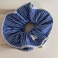 Detalle de coletero a rayas azules con costura blanca y etiqueta de lazo plateado - Rayas Azul Marino