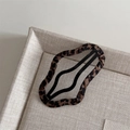 Close-up of leopard print fabric-wrapped hair clip with black matte metal frame - Leopard Wrapped Wave