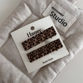 Detailed macro view of two rectangular leopard print hair clips on a white brand card - Rectangular Style
