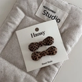 Detail view of handmade leopard print bow hair clips set on a white display card - Bow Style