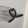 Detailed view of large black and white houndstooth fabric hair claw clip on book - Small Black & White Print