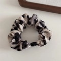 Detailed shot of leopard print scrunchie fabric with elegant black fixing buckle accent - Beige Leopard Print