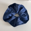 Nahaufnahme des denimblauen Scrunchie aus Faltenstoff mit Fokus auf Textilstruktur - Dunkelblau