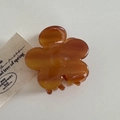 Detailopname van de amberkleurige bloem haarclip van acetaat met glanzende afwerking - Bruin