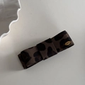 Gros plan sur la barrette nœud léopard avec plaque dorée gravée du mot Love - Pince Double Nœud Léopard Café Foncé