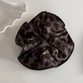 Détail d'un chouchou léopard avec texture soie et un petit pendentif doré Love - Chouchou Léopard Café Foncé