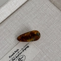 Detail of tortoiseshell acetate hair clip with elegant waterdrop shape on rustic fabric - Blue Coffee