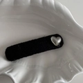 Dettaglio della clip per capelli in tessuto nero con cuore d'argento su vassoio bianco - Cuore d'Argento Martellato Clip BB Lunga Nera