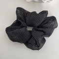 Détail d'un chouchou noir à pois en organza avec une texture de tissu doux et plissé - Noir