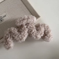 Dettaglio della trama della pinza per capelli ondulata in pile beige effetto lana - Cammello