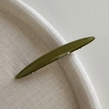 Detailopname van de olijfgroene acetaat haarclip met hoogglansafwerking en lang ontwerp - Groen