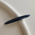 Detailopname van een minimalistische zwarte haarklem met een gladde glanzende afwerking - Blauw
