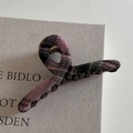 Dettaglio della molletta per capelli a scacchi rosa e verdi con denti antiscivolo interni - Pinza Appendiabiti