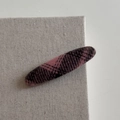 Detail view of oval hair clip featuring classic dark magenta and black plaid fabric texture - Long Oval