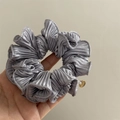 Detail of silver pleated scrunchie fabric with gold metal charm and silky texture - Blue
