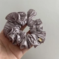 Detailed texture of dusty purple pleated satin scrunchie with handmade gold charm - Dark Purple