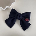 Dettaglio del fermaglio per capelli a fiocco blu navy con ciliegie su sfondo bianco - Fermaglio con Fiocco e Ciliegia Blu Marino