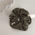 Vue macro détaillée du chouchou rétro vert olive avec une texture de tissu douce - vert clair