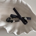 Close-up of gray fabric bow hair clip with decorative heart and smile bead chain detail - Diagonal Knot Duckbill Clip / Gray