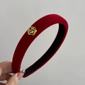 Dettaglio ravvicinato del cerchietto in velluto rosso con un elegante rosa dorata in rilievo - Versione Stretta / Rosso