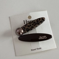 Detailed view of leopard print hair clip with gold logo lettering on card - Leopard Coffee Long Oval