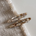 Vue détaillée de barrettes en acétate avec texture marbrée ambre sur fond en tissu beige - Abricot Lacté