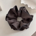 Close-up of dark grey large scrunchie made of textured fabric on a white ceramic plate - Khaki