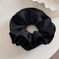 Detailed macro view of black oversized ruffled scrunchie with twill fabric texture - Black