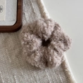 Gros plan d'un chouchou en peluche kaki sur un tapis de table tissé en gros plan - Kaki
