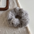 Vue macro détaillée de la texture du tissu peluche gris sur le chouchou élastique épais - Gris clair