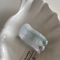 Nahaufnahme der Haarspange aus Acetat in Blau und Violett auf einer weißen Muschelschale - Hohe schmale Acetatkralle - Blauweiß