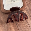 Detail showing the inner France Handmade gold logo on the tortoiseshell hair claw clip - Coffee Acetate