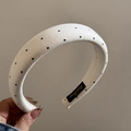 Detailed macro view of the padded white headband with black polka dots and interior brand label - White