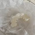 Detailed macro view of cream wavy hair claw clip with elegant marble resin texture - Wave Sawtooth Flower - White