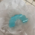 Macro shot of light blue translucent wave-shaped claw clip on white crinkle paper - Wave Sawtooth Flower - Blue