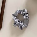 Close-up of elegant silver grey satin scrunchie with soft silk texture and pleated detail - Silver Grey - Standard Scrunchie