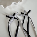 Gros plan de barrettes à nœuds double épaisseur avec longs glands en noir et argent - Nœud à ruban / Patchwork Noir