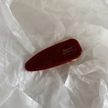 Detailed macro view of dark red acetate hair clip with golden Barrette La France text - Burgundy