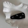 Détail d'une barrette BB noire avec quatre nœuds argentés sur un plateau en céramique blanc - Pince à Cheveux Nœud en Cuir / Noir