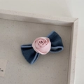 Détail du nœud en denim bleu et de la pince à cheveux rose satinée montrant la texture - Rose Denim Rose - Petit Nœud