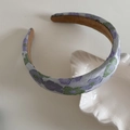 Detailopname van vintage paarse jacquard haarelastiekje op een wit keramisch plateau - Monet Paarse Bloem Hoofdband