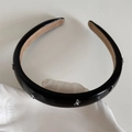 Detail of black glossy headband with silver bow studs on white ceramic tray - Leather Bow Headband / Black